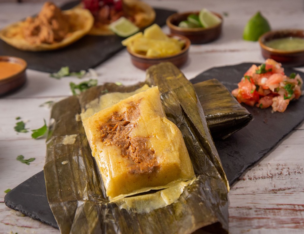 tamal oaxaqueno abierno con carne de puerco y salsa roja